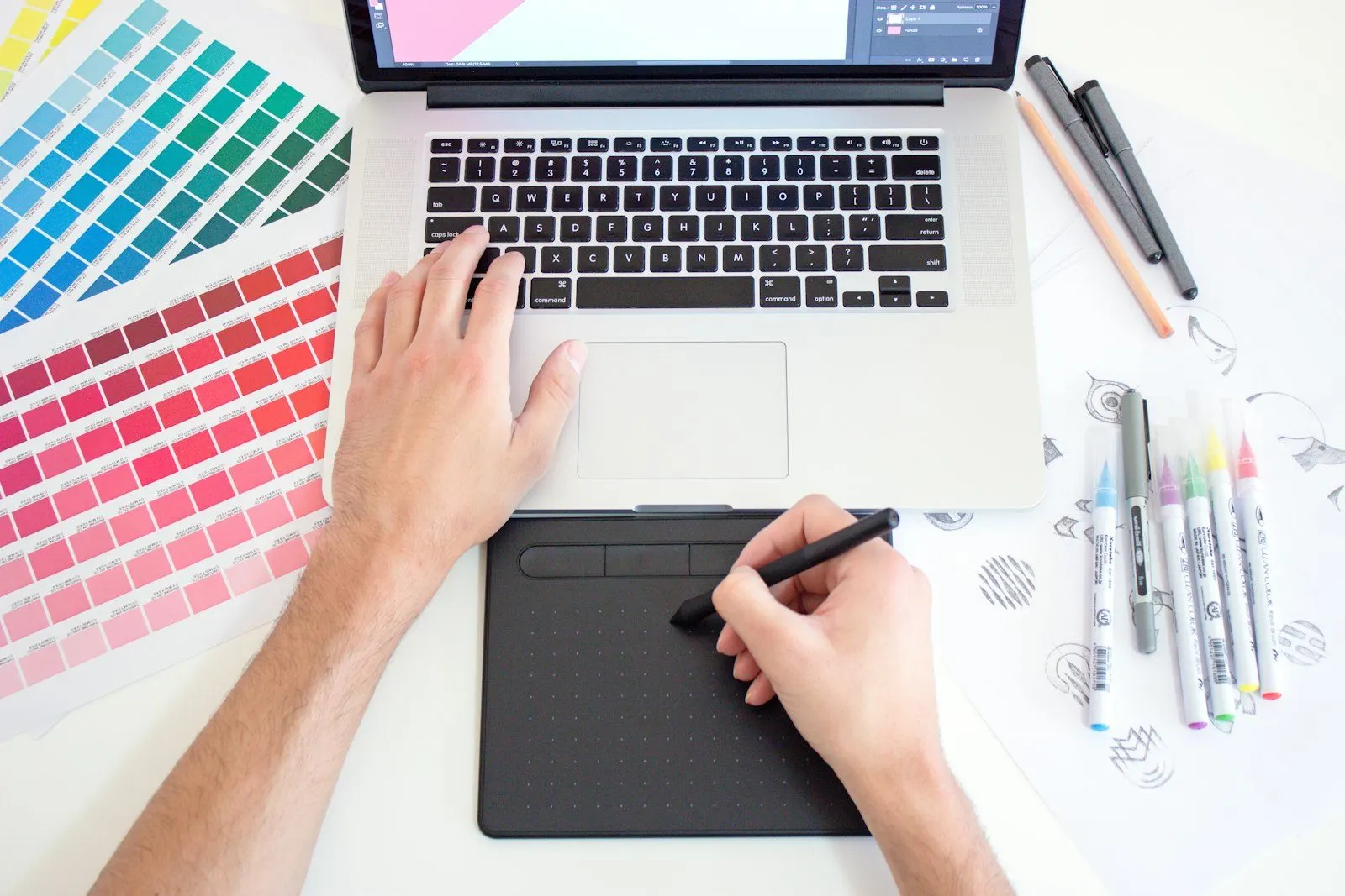 Diseñador trabajando con tableta y muestrario de color